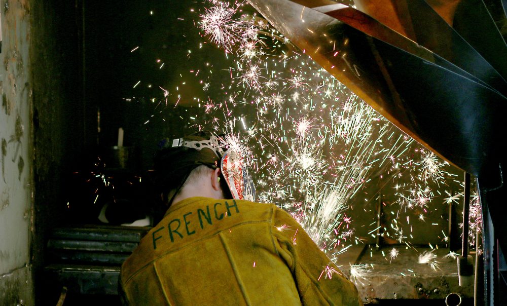 Maritime welder with sparks flying.