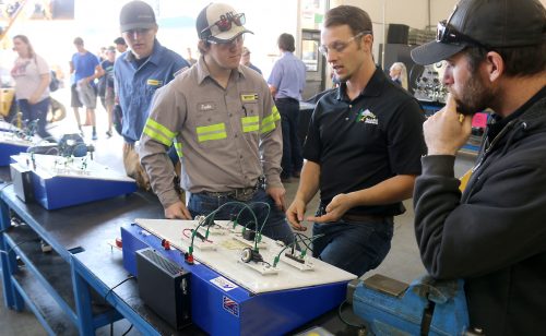 PCC student shows high schoolers an electrical board.