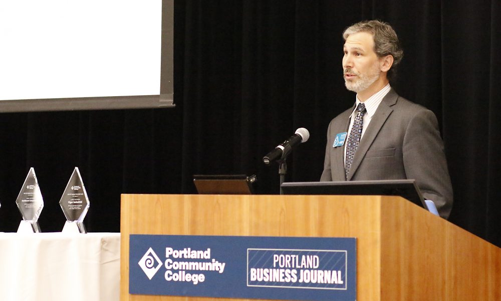 Marc Goldberg speaks at podium.