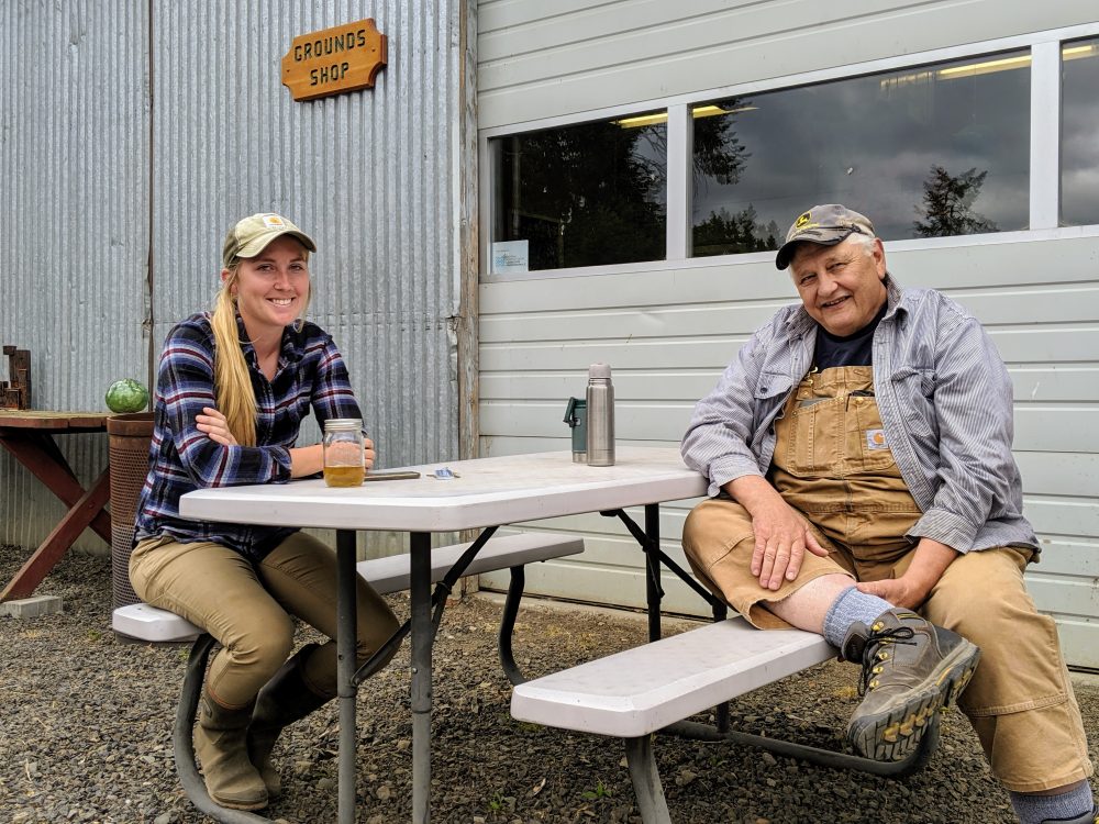 woman and man sitting at an outdoor table, smiling