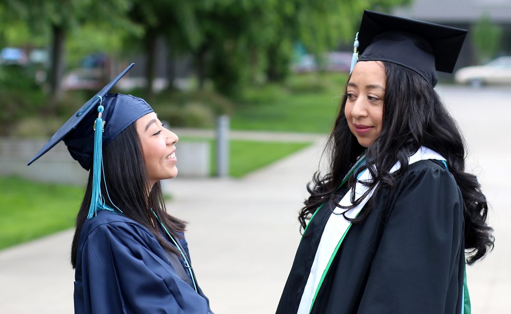 Veyda and Margarita look at each other in SE campus quad.