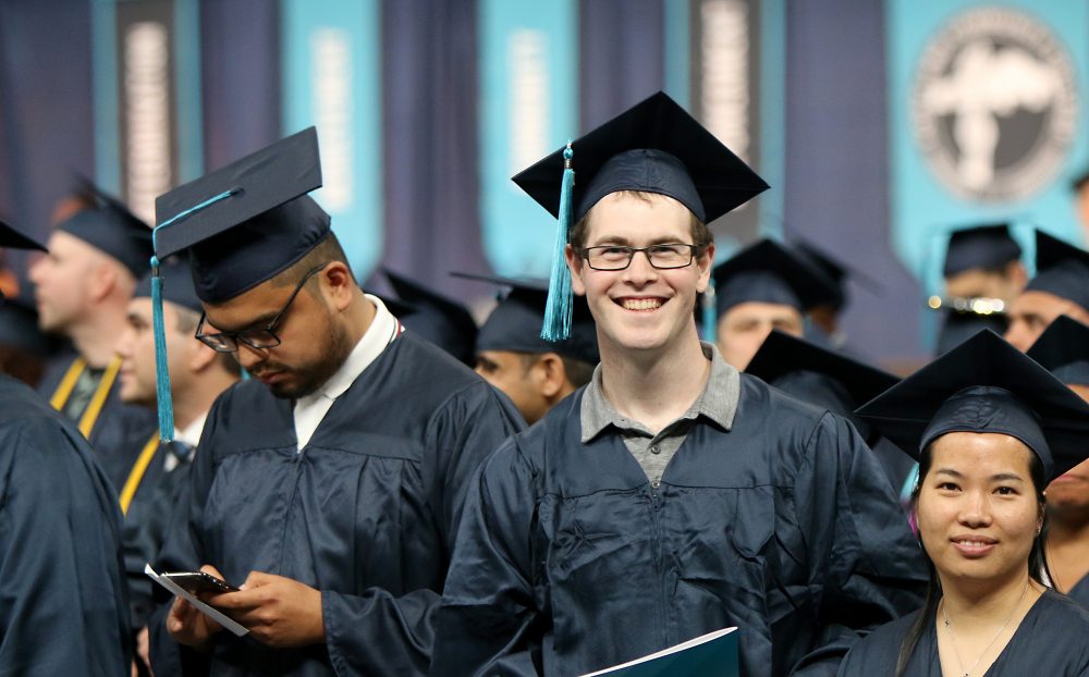 Student smiles on coliseum floor.