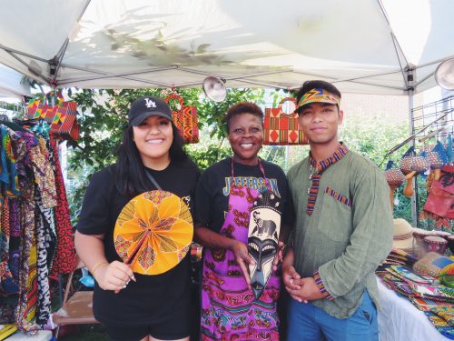 Student leaders Anita Phomma (left) and Nishant Shrestha pose with one of the many vendors at the Jade District Night Market.