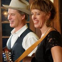 man and woman musicians holding guitars