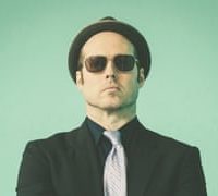 musician in suit, hat, and sunglasses