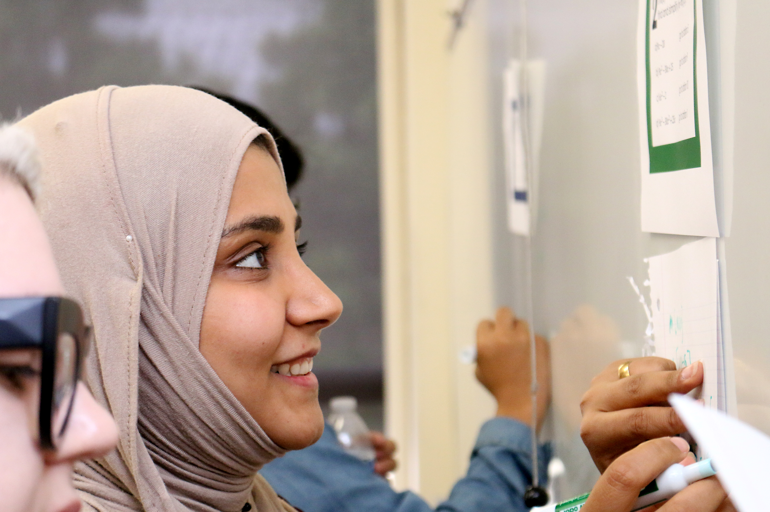 Student Braa Aldebi works on a problem with her classmates.