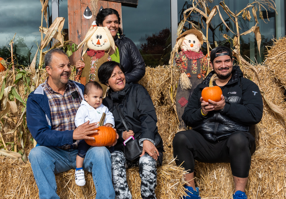 family posing for a photo on hay bales