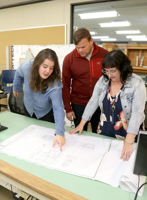 Students check out permit plans in class.