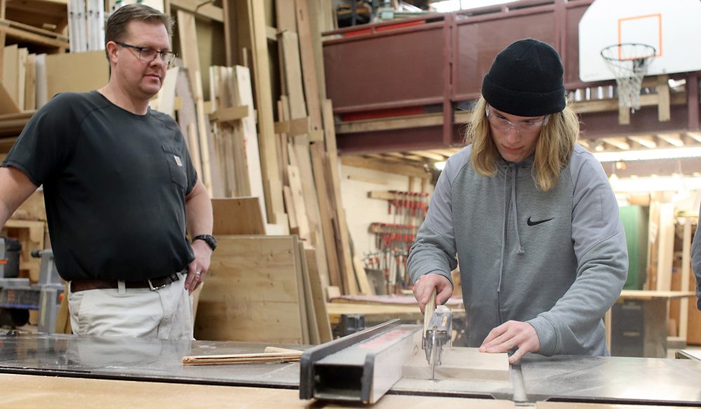 Alex Block carves a piece of wood.