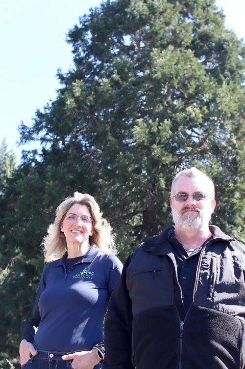 Anne LeSenne and Jack Lussier pose in front of trees.