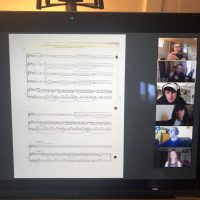 screenshot of sheet music and students in a video meeting