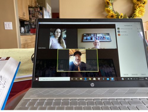 laptop showing three people in a video conference