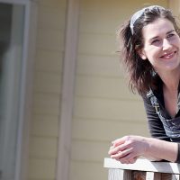 Erin Beaty leaning on a home railing