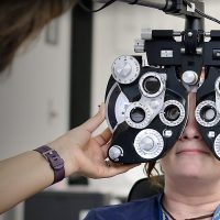 Students practicing with eye exam equipment