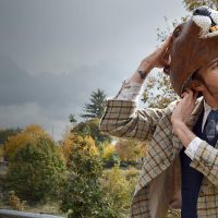 Kitko stading outside and taking off a beaver mask