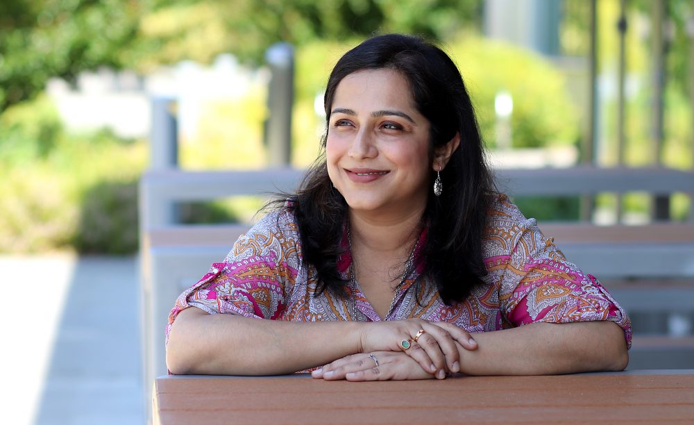 Poulami Mitra sits on park bench.
