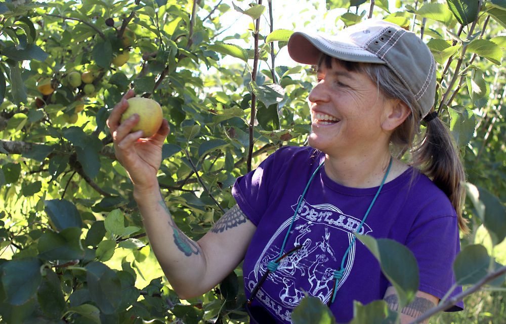 Miriam Latzer with apple in the orchard.