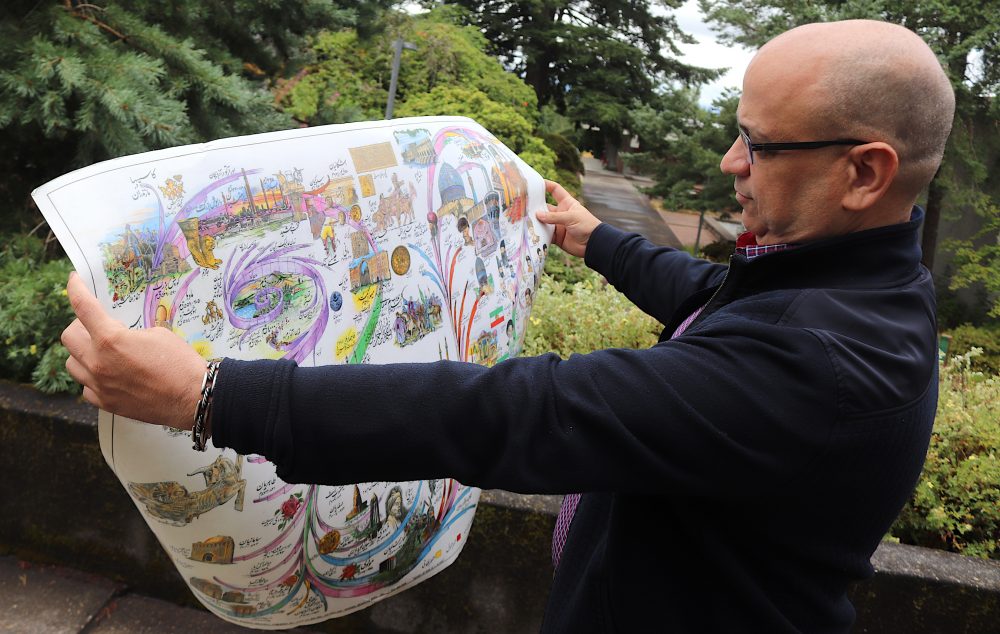 Esteghlalian displays a poster of Persian history.