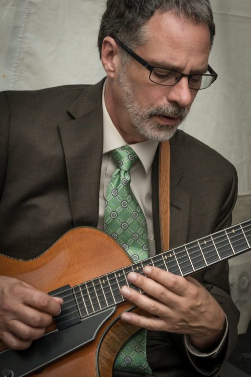 Man in suit holding guitar