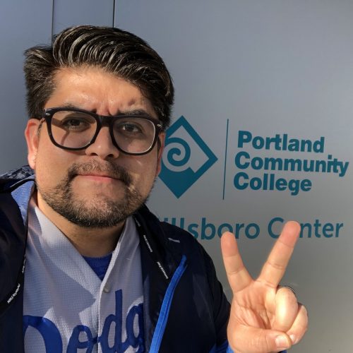 Esparza flashing peace sign in front of PCC Hillsboro Center sign