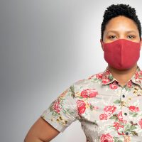 Ebony Frison standing with hands on hips and wearing a mask