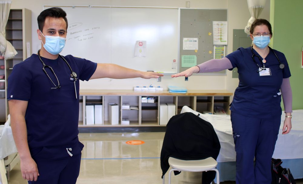 Students show how to socially distance.