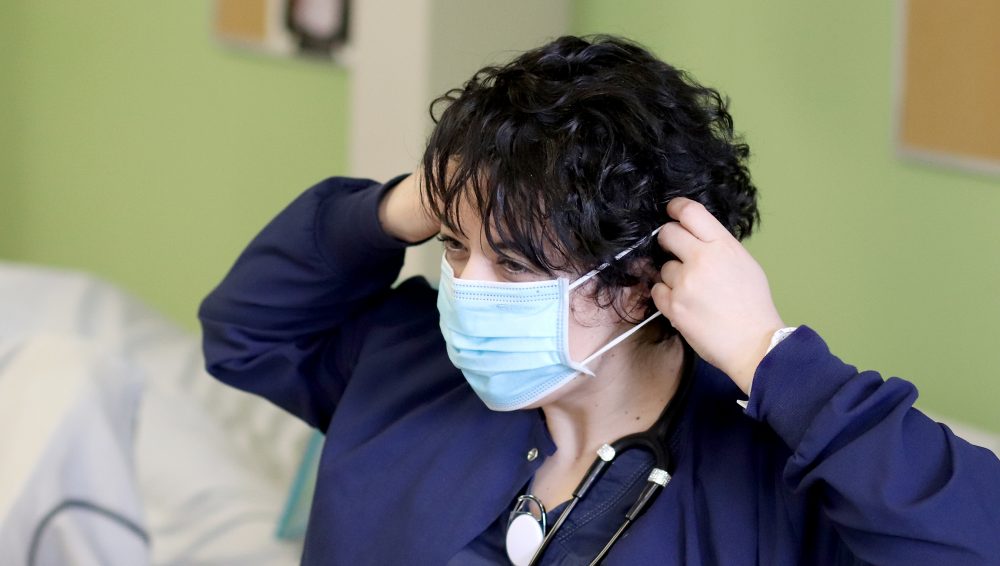 Student putting on mask.