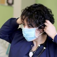 Student putting on mask.