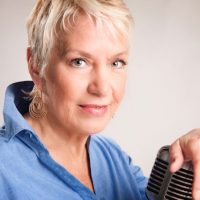 woman with hand resting on a microphone