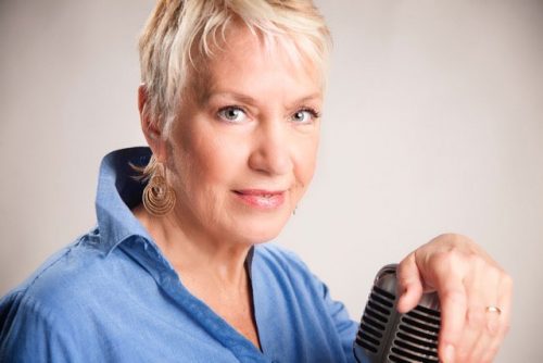 woman with hand resting on a microphone