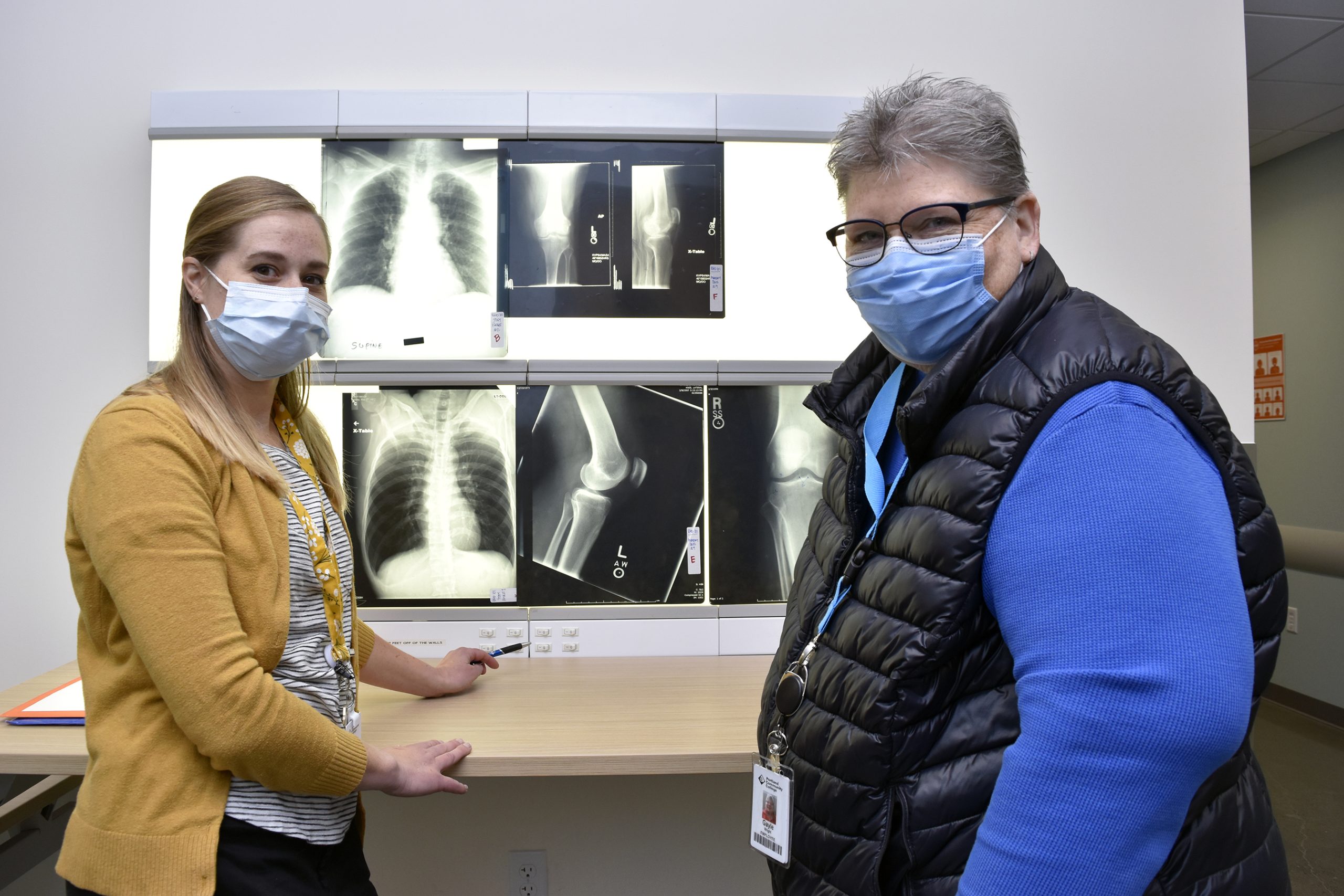 Student and Gayle Wright in front of x-rays.