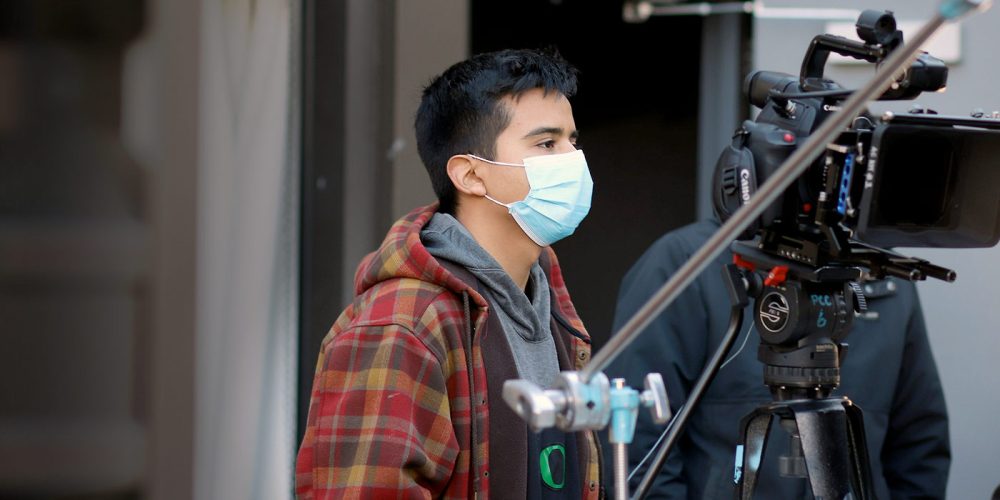 Video Production student in the studio with a camera