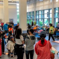 community members and health professionals in line and at tables getting vaccinated