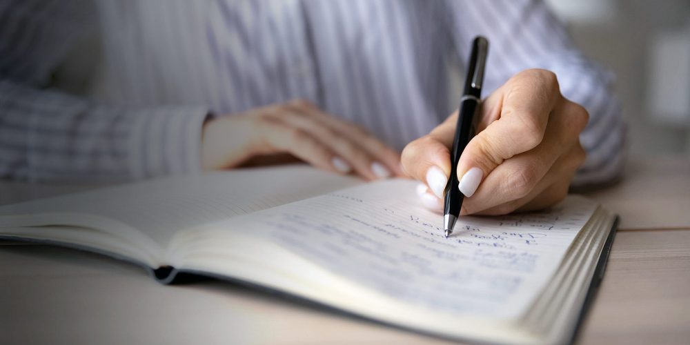 Close-up of a woman writing in a notebook