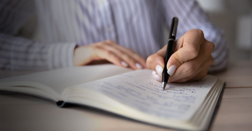 Crop close up of Caucasian woman sit at desk at home office write make notes in notebook. Female employee or worker handwrite in notepad, engaged in time planning or management. Habit concept.