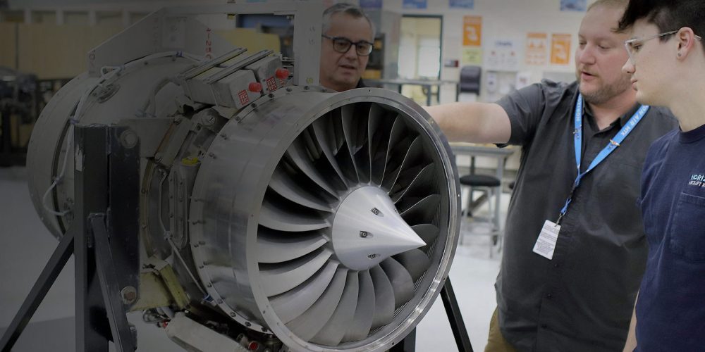 Students and instructors working with a jet engine