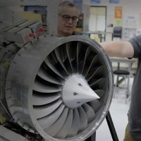 Students and instructors working with a jet engine