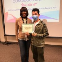 Tracee Wells standing with a student who is holding up a certificate of completion from spring 2022 cohort