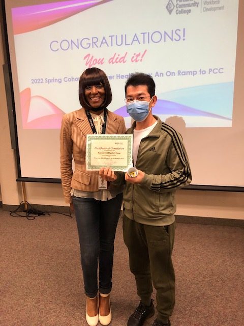 Tracee Wells standing with a student who is holding up a certificate of completion from spring 2022 cohort