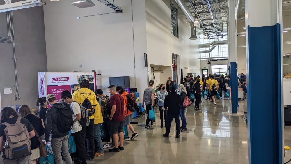 students visiting with industry representatives inside manufacturing training center