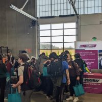 students visiting with industry representatives inside manufacturing training center