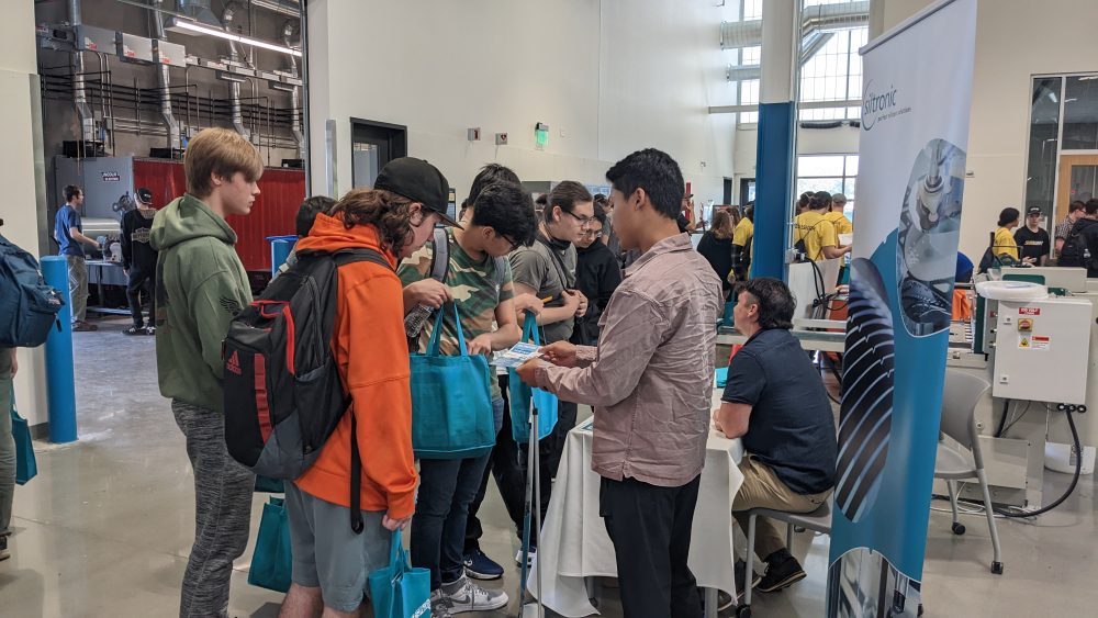 students visiting with industry representatives inside manufacturing training center