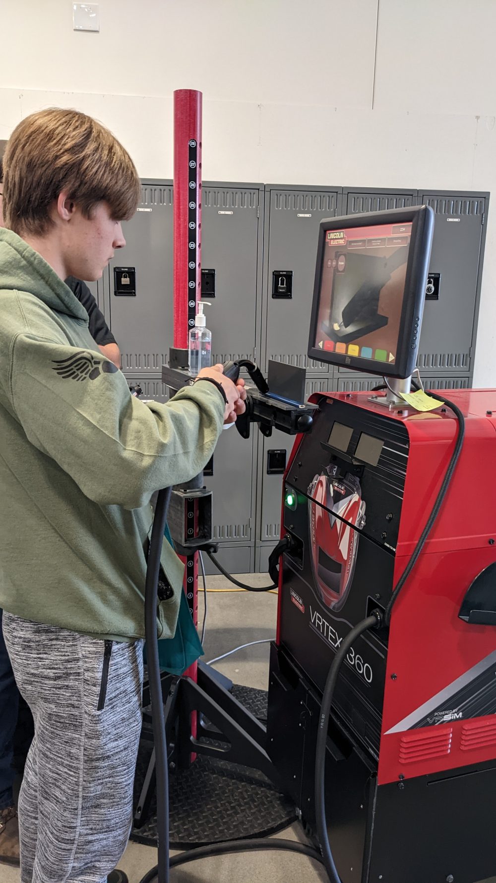 high school boy using welding virtual simulator