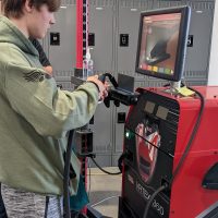 high school boy using welding virtual simulator