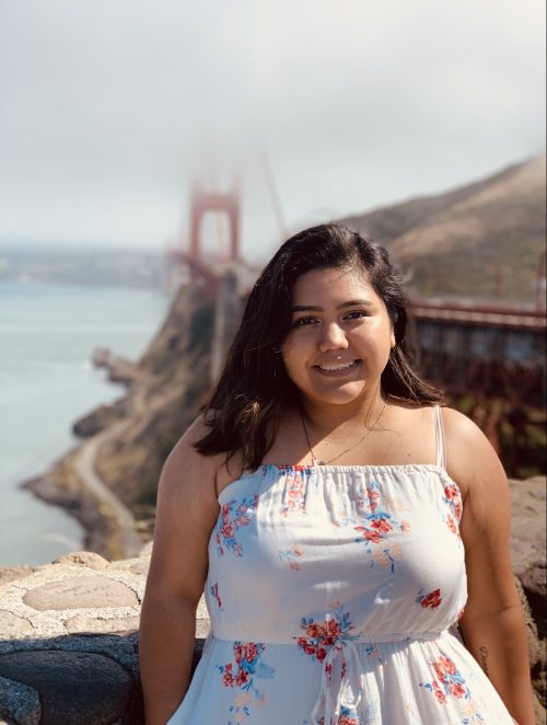 woman smiling with San Francisco's Golden Gate Bridge in the background