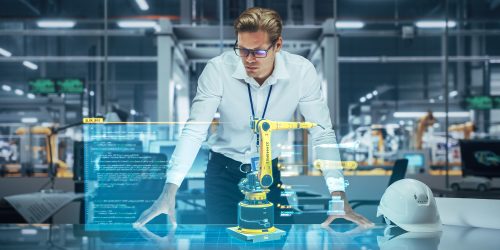 Industry 4.0 High-Tech Factory: Robotics Engineer Working on Robot Arm Design, Using Augmented Reality Hologram to Analyze Conceptual 3D Model. Futuristic Engineering with Digital Technology