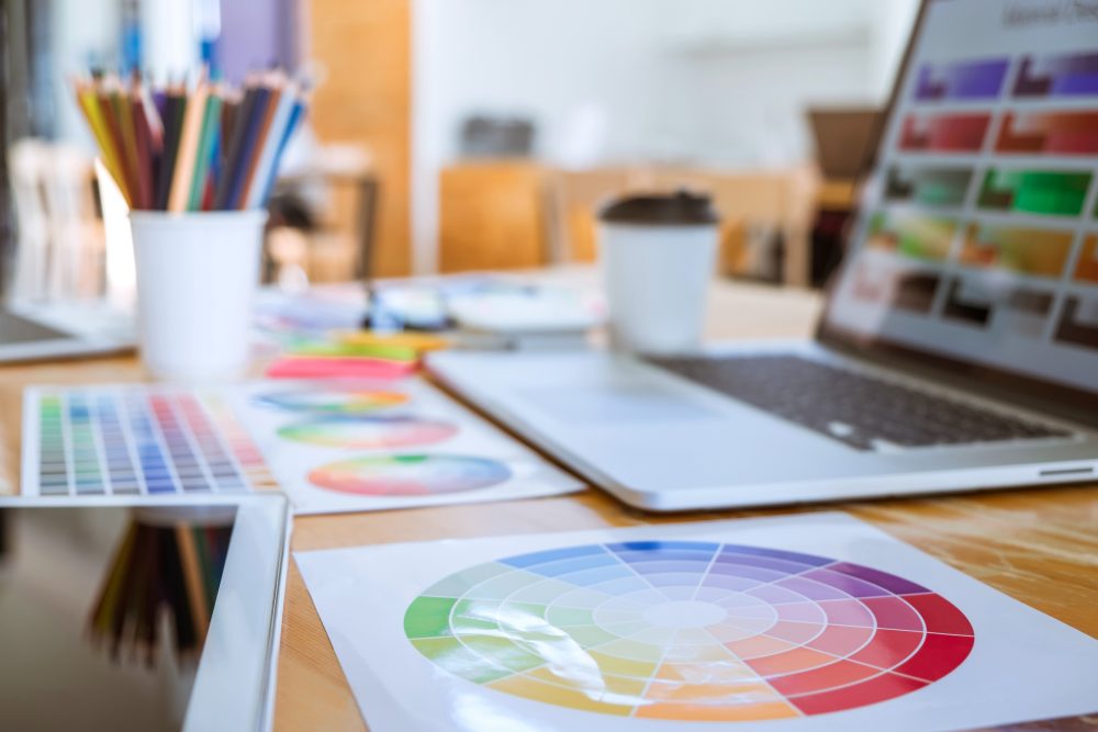 Graphic designer object tool and color swatch samples at workspace.