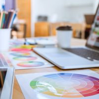 Graphic designer object tool and color swatch samples at workspace.