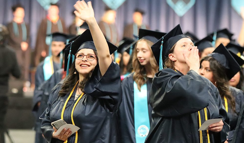 graduates waving