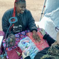 Student getting colorful henna design on her hand.
